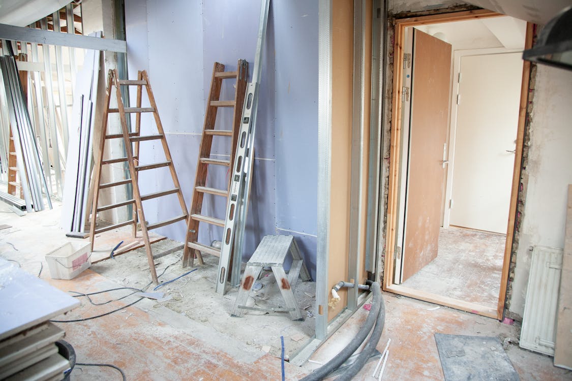 Commercial office space mid-renovation with exposed framing, drywall, and ceiling systems