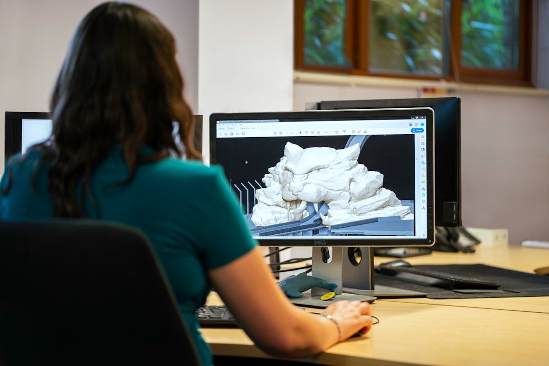 Engineer reviewing a 3D digital model on a computer monitor in an office